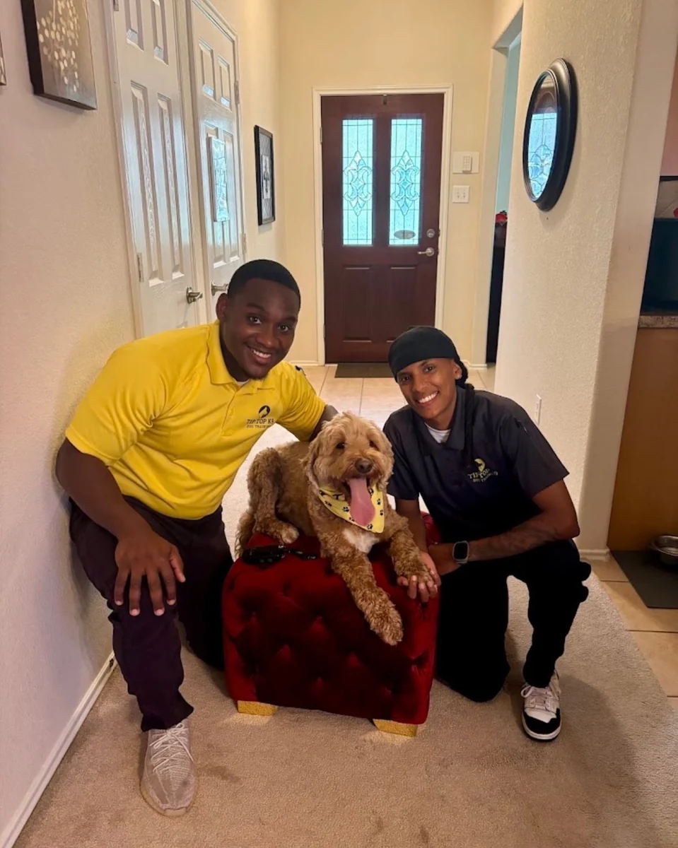 Ahmad Bradshaw, lead trainer at Tip Top K9 Humble, with a client's Goldendoodle during an in-home session
