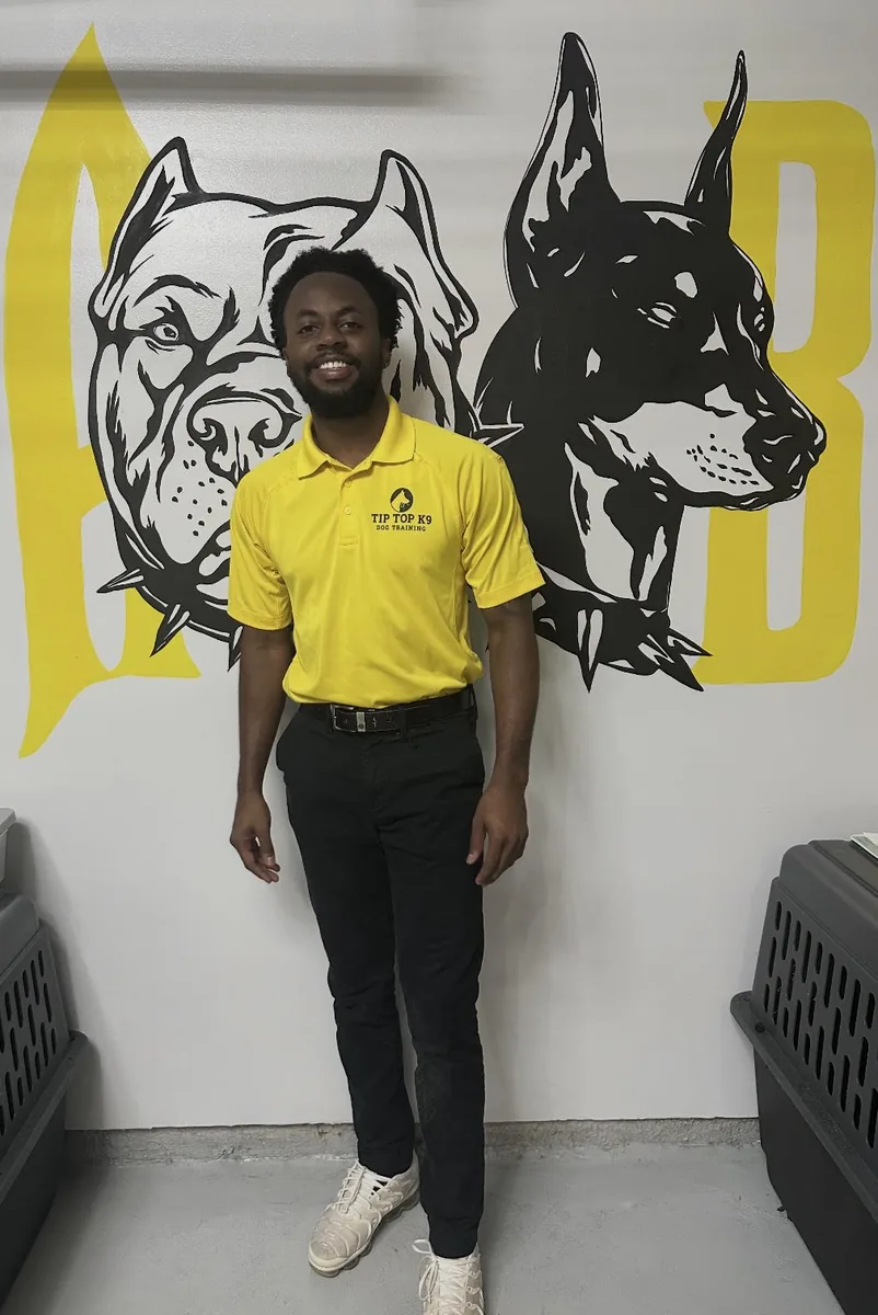 Jerome Drakeford, dog trainer at Tip Top K9 Humble, in front of the Tip Top K9 mural